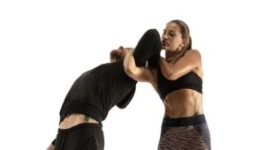 Man and woman fighting in studio, women's self-defense concept