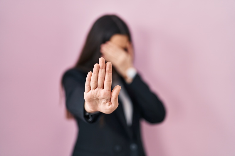 Young brunette woman wearing business style over pink background covering eyes with hands and doing stop gesture with sad and fear expression. embarrassed and negative concept.