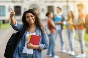 Education Concept. Smiling Black Female Student Showing Thumb Up While Posing Outdoors