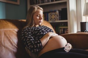 Pregnant woman relaxing in living room at home